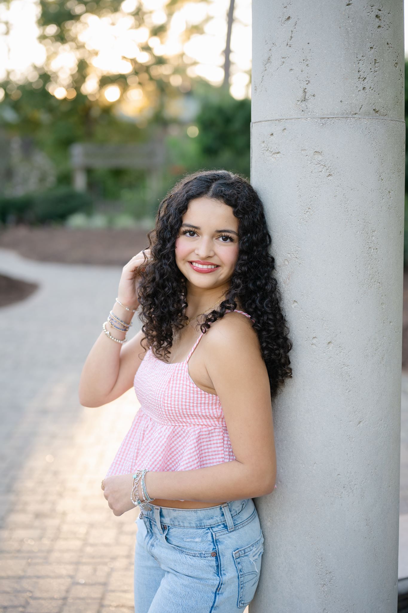 Senior portrait of Cristina leaning against column at Mercer Arboretum.