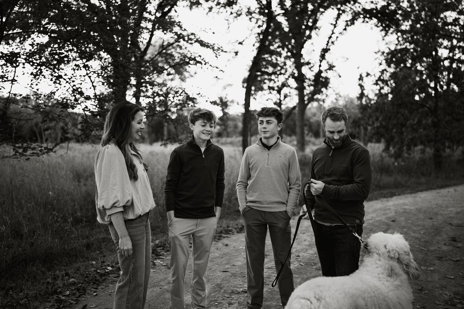 Black and white family portrait of four people chatting during fall session in Oakbrook, IL
