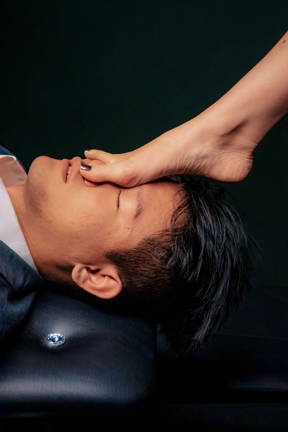 A man lying down receiving a facial massage treatment at a professional spa or wellness center.