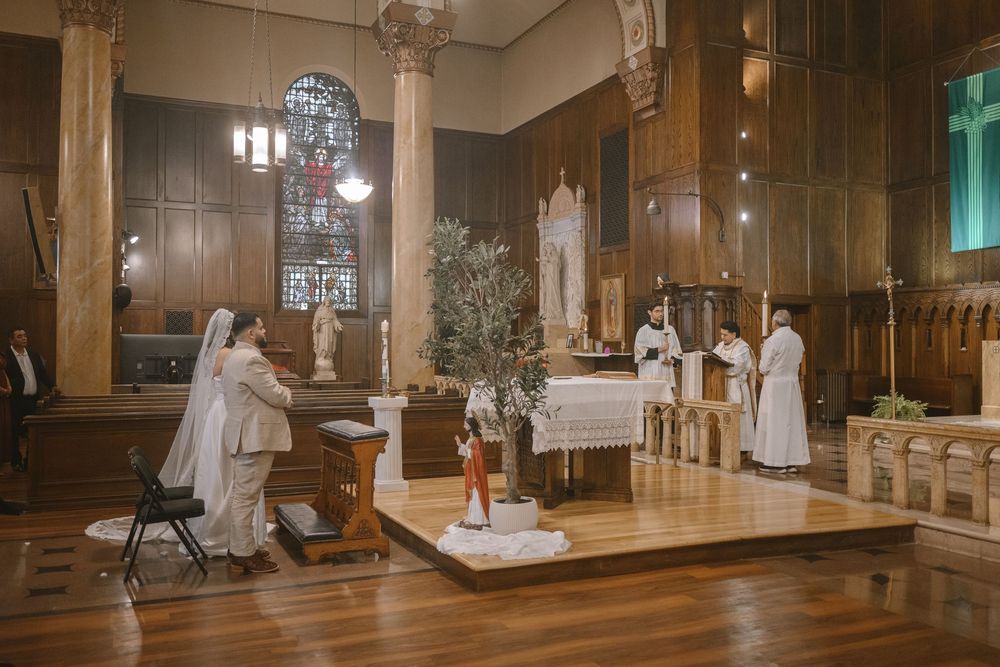 Bride and groom exchange vows at ornate church altar during intimate wedding ceremony.