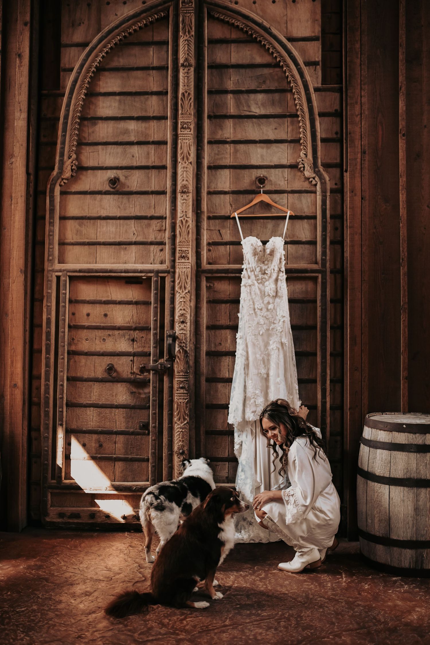Bride sharing a sweet wedding morning moment with her puppies and gown