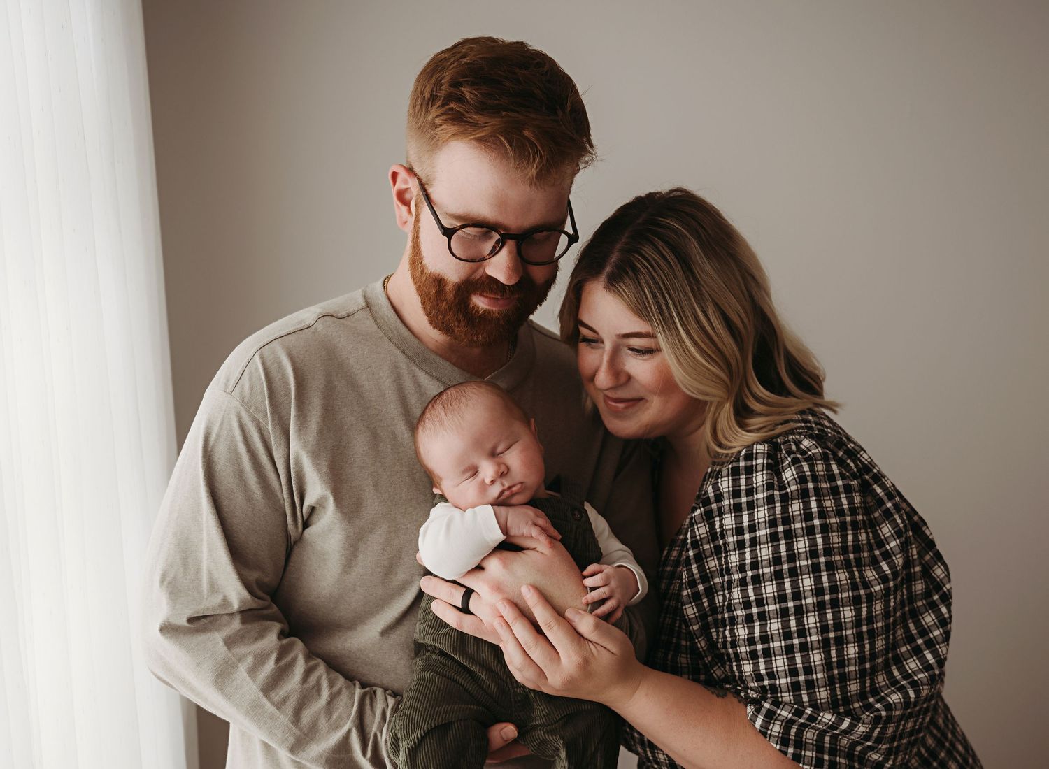 Newborn studio portraits session in Nacogdoches Texas with a mother and father snuggling their newborn baby.