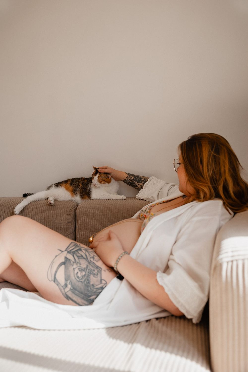 Chat installe sur le canape du salon, partenaire discret de la seance photo grossesse