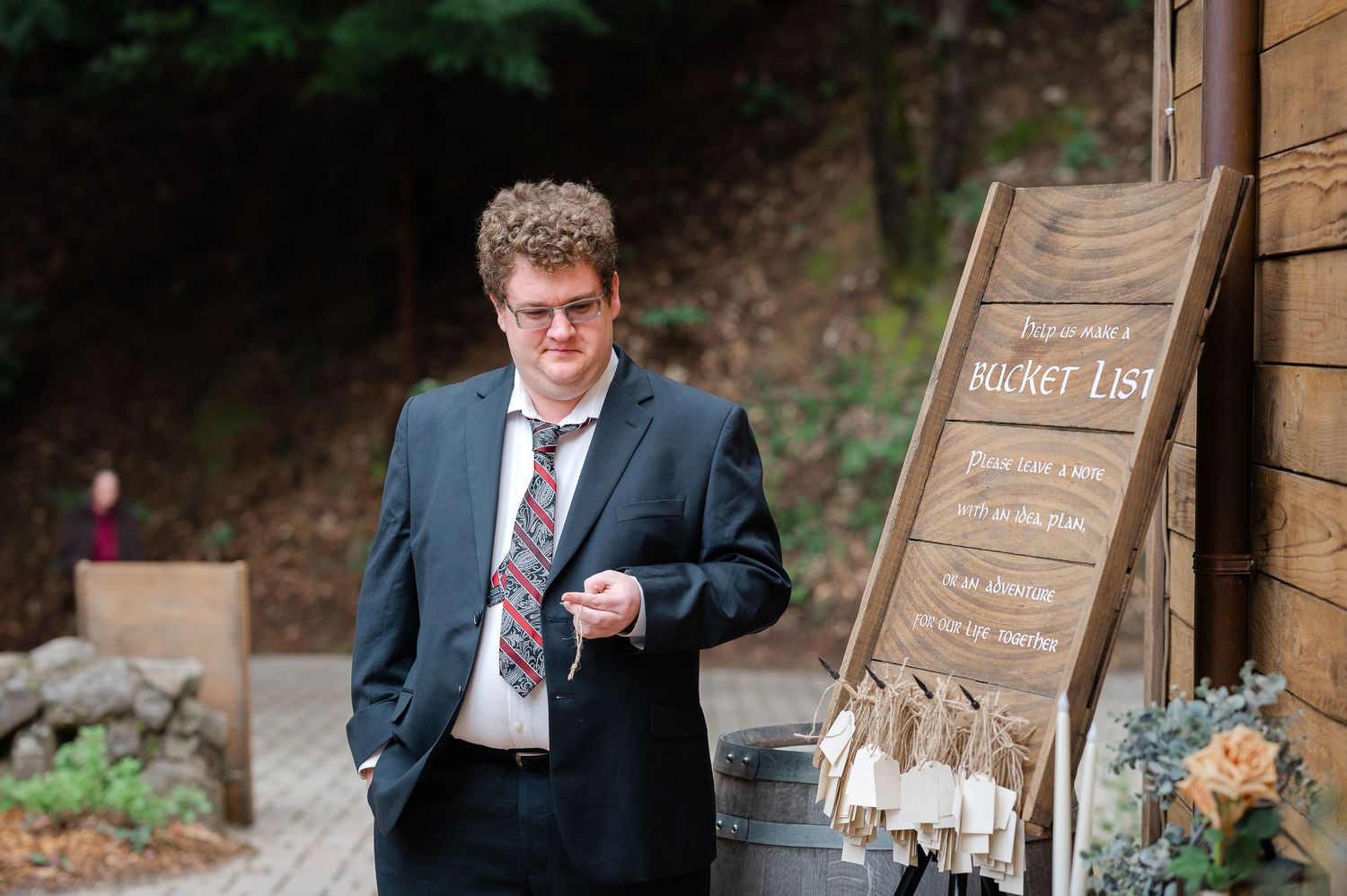Lord of the Rings themed wedding ring toss game with gold rings on black stands and rustic wooden signs outdoors.