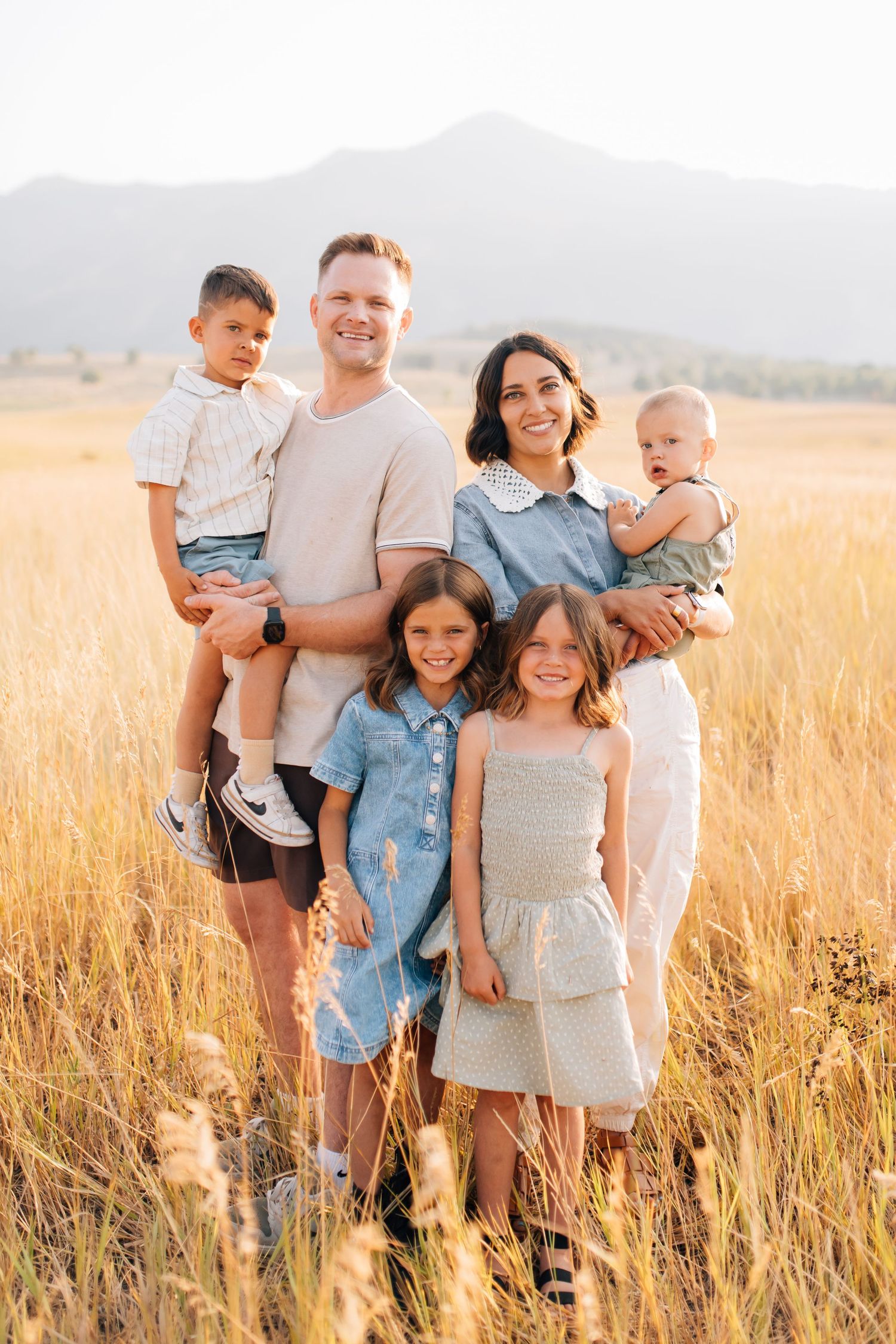 Family shares tender moment under blooming white tree branches in spring.