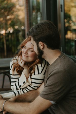 A couple shares an intimate moment on an outdoor patio at sunset.