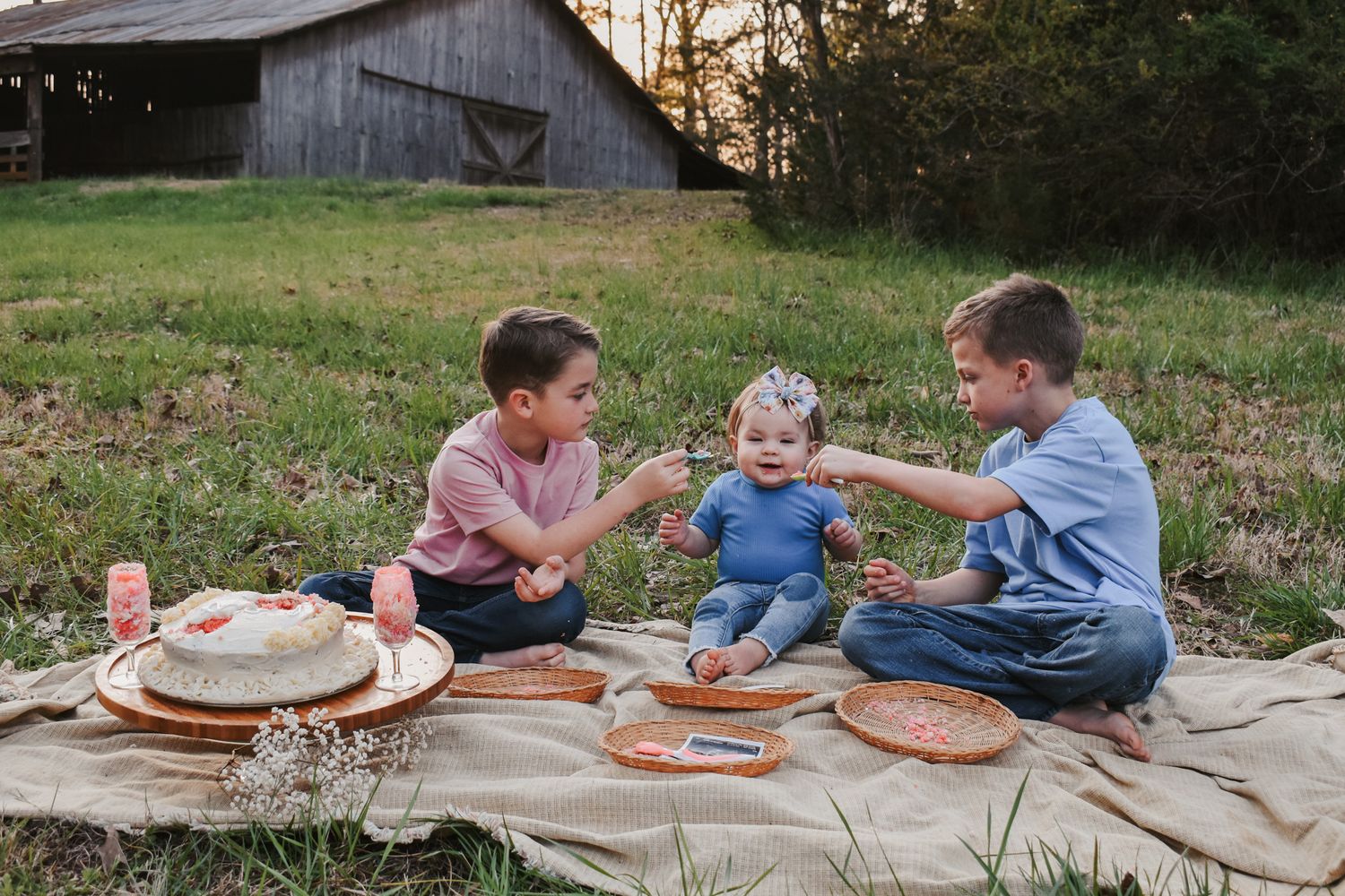 Group seated on blanket sharing treats and playing games outdoors.
