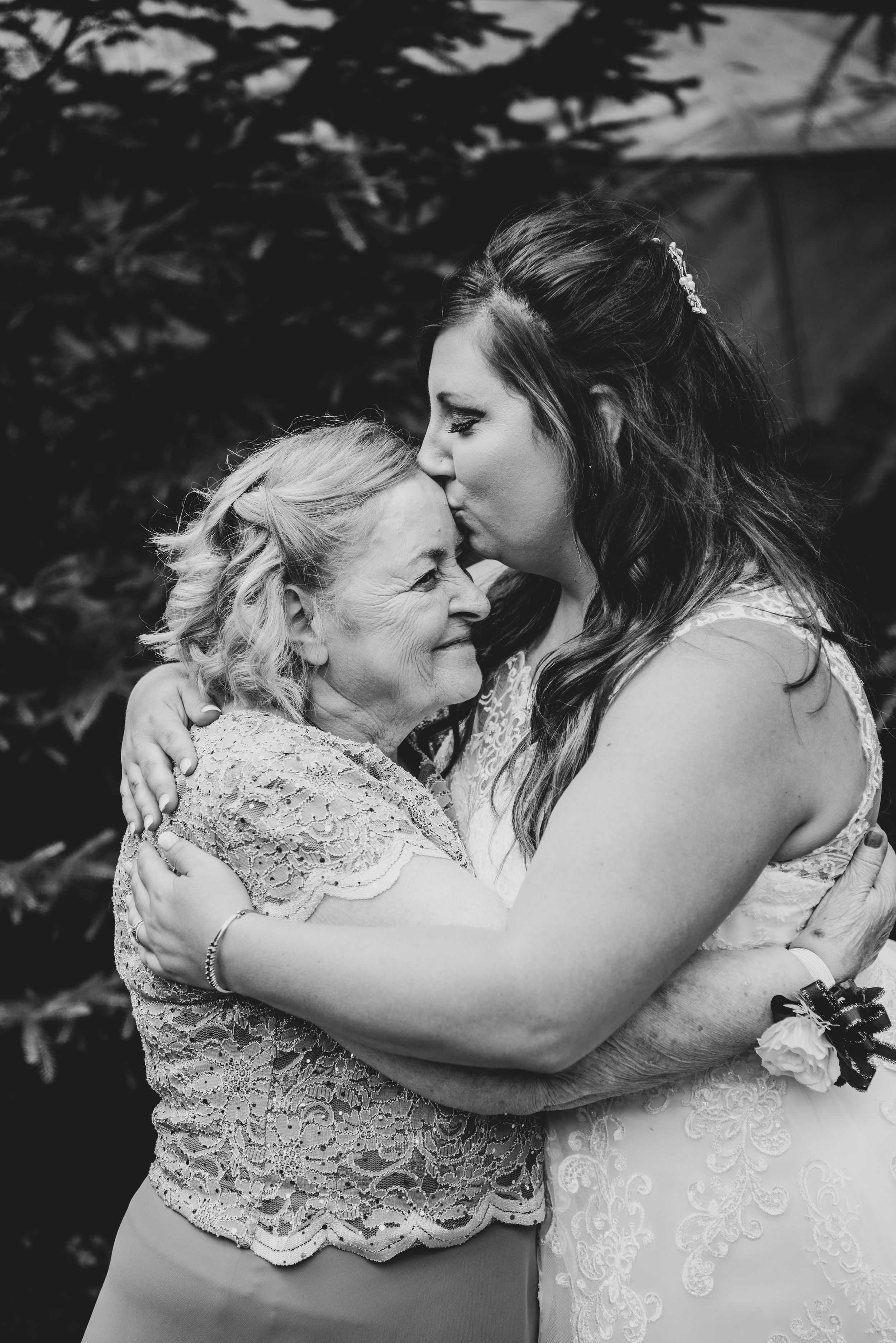 An emotional black and white embrace between two people at a wedding.