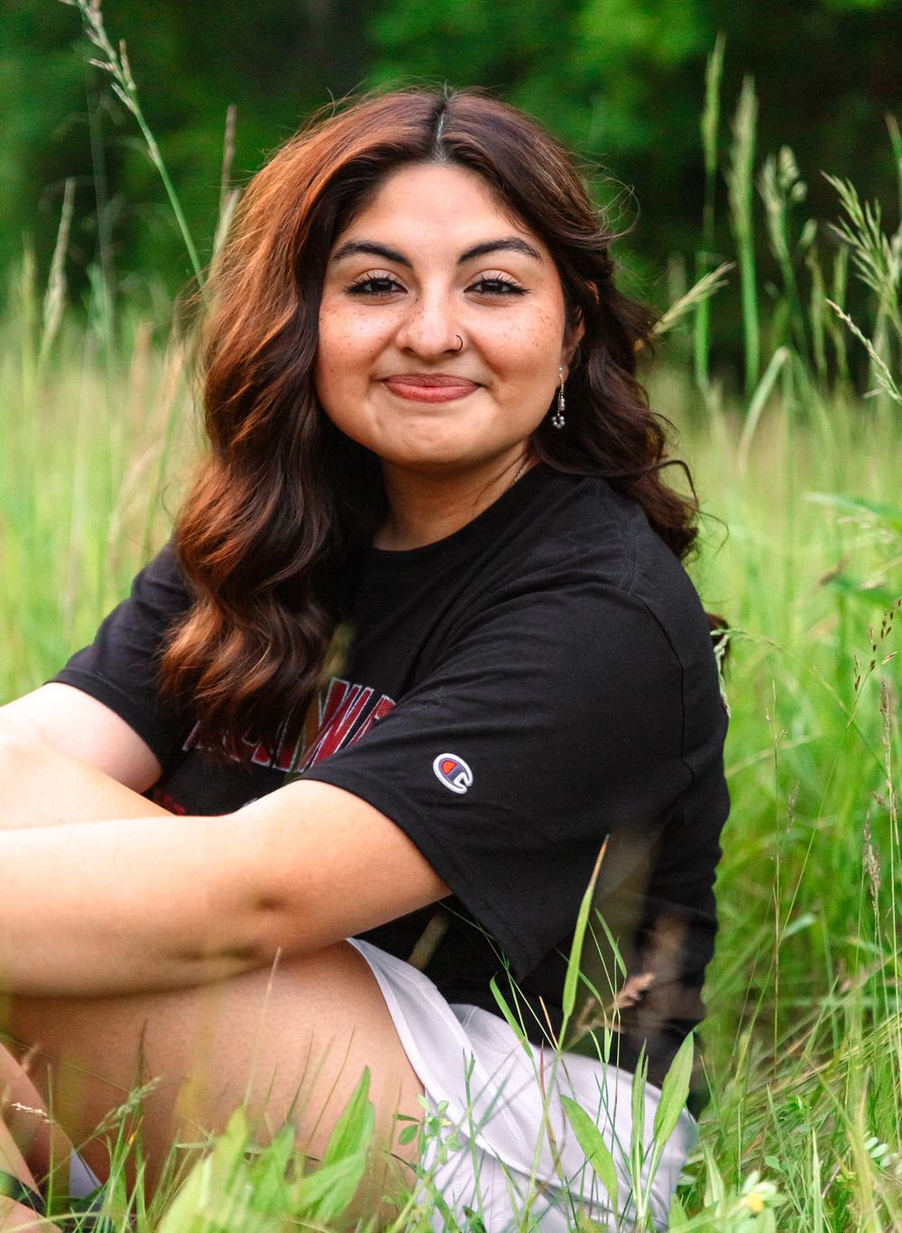 Casual outdoor photoshoot in a field with vibrant green background.