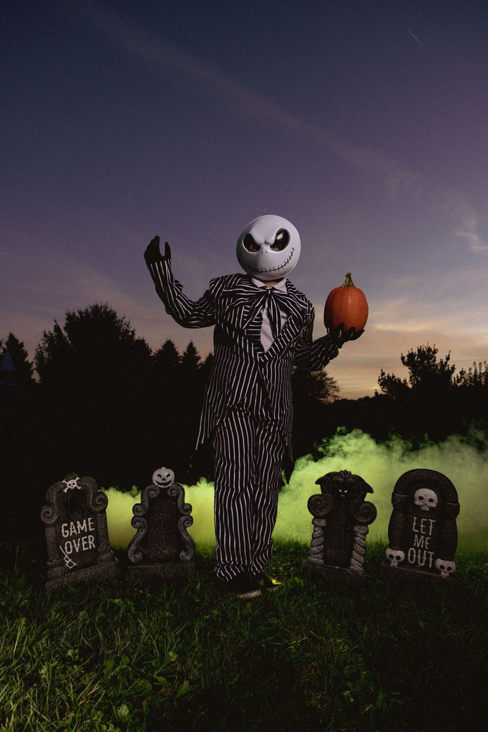 Jack Skellington yard decorations from Nightmare Before Christmas with spooky green lighting at dusk.