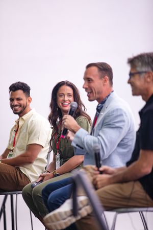 A group of professionals sitting together and laughing during a casual business meeting or presentation.