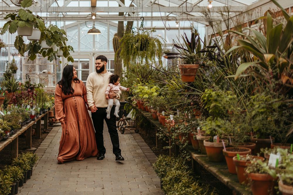 Elegant greenhouse wedding ceremony with lush plants and natural light streaming through glass panels.