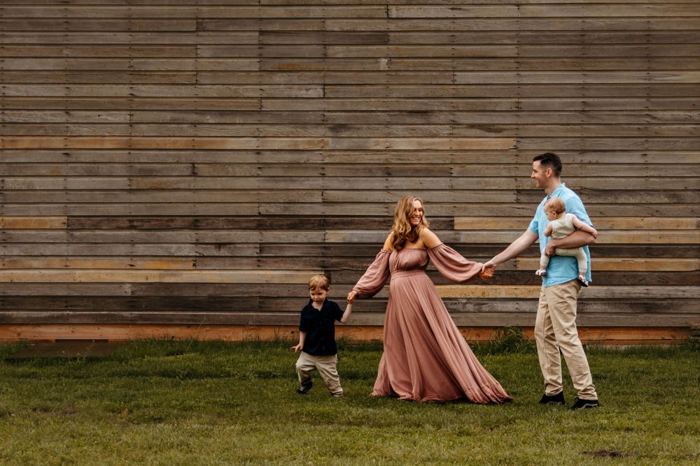 Playful family sequence showing them walking and spinning together on a wooden deck at sunset.