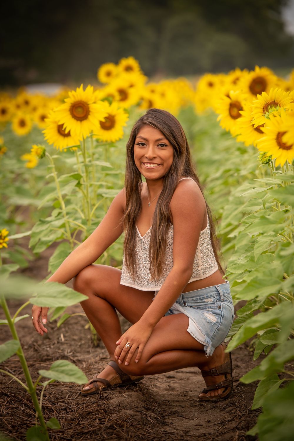 Portrait among tall sunflowers with warm evening light filtering through the flowers.
