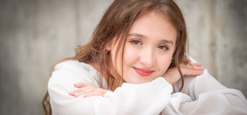 Portrait of a young person in white clothing with a gentle expression.
