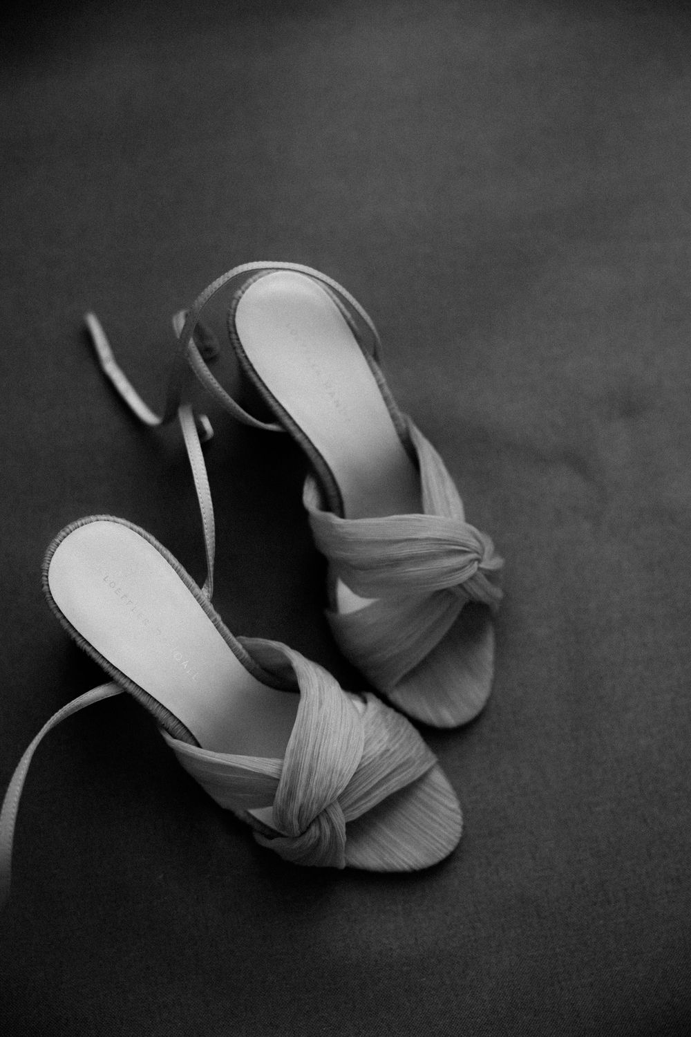 Elegant draped sandals in neutral tone photographed in black and white.