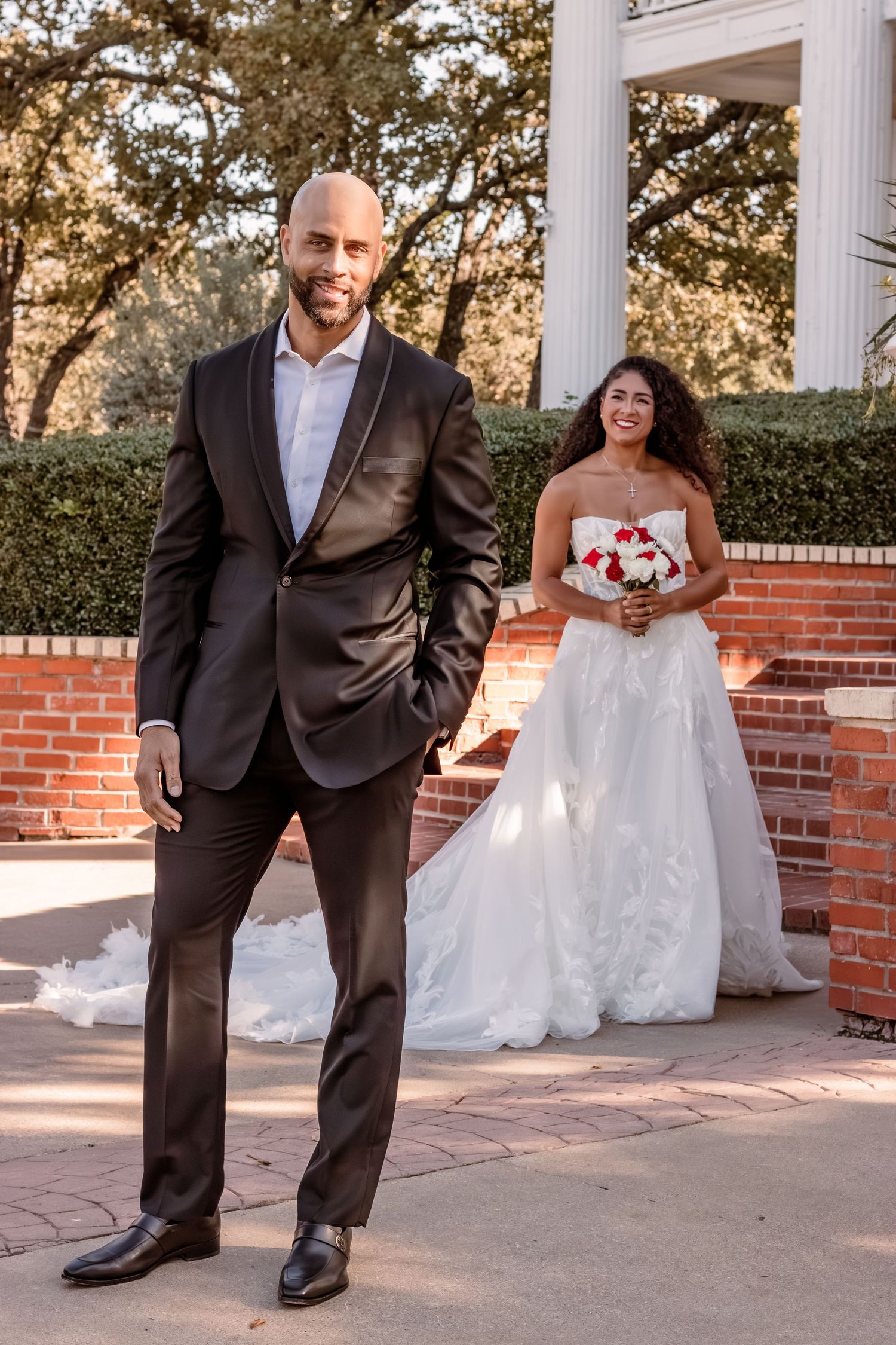 Elegant wedding photo featuring couple in formal attire by classic white columns.