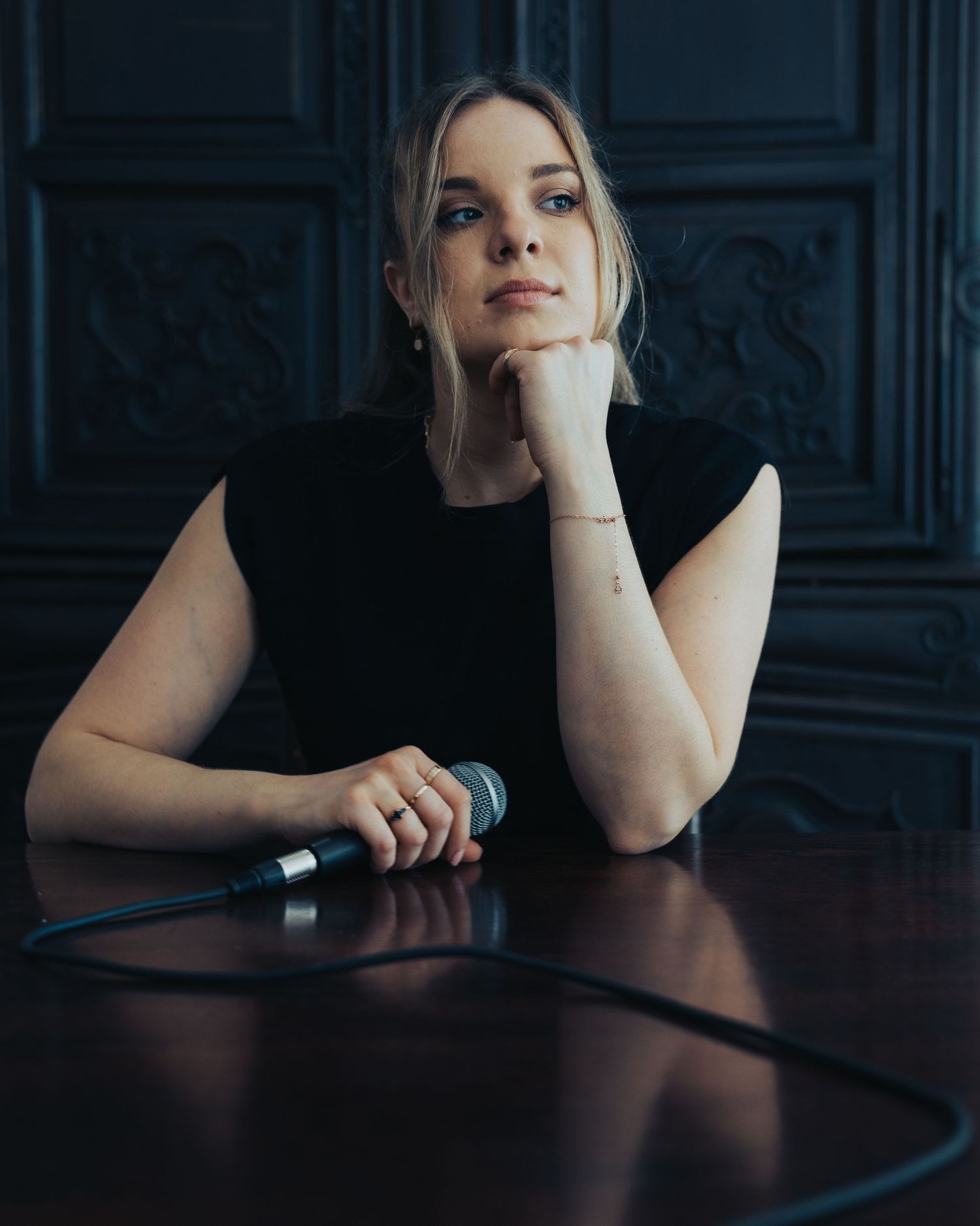 Moody portrait series in dark lighting against an ornate background.