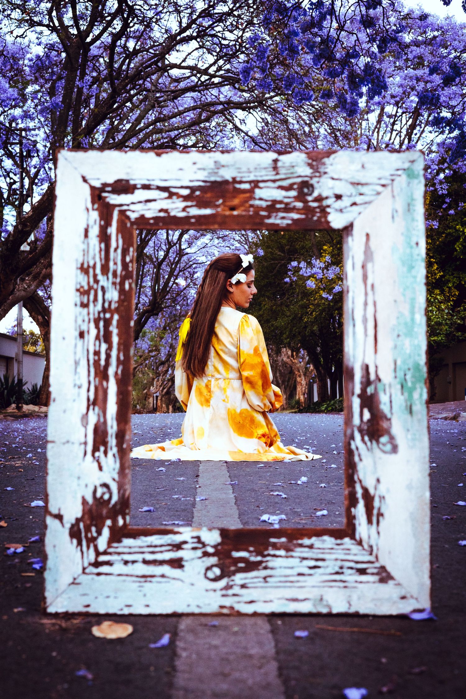 A series of photos showing a yellow-orange figure framed through a rustic white window frame against a natural backdrop.