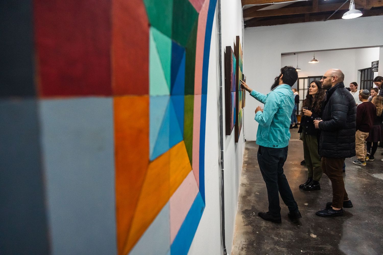 Series of colorful abstract paintings displayed in a white-walled gallery space.