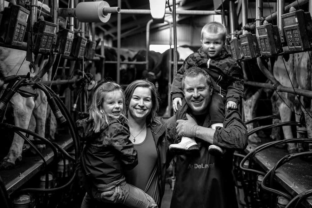 Black and white photograph of a family posing together inside what appears to be a commercial kitchen or restaurant.
