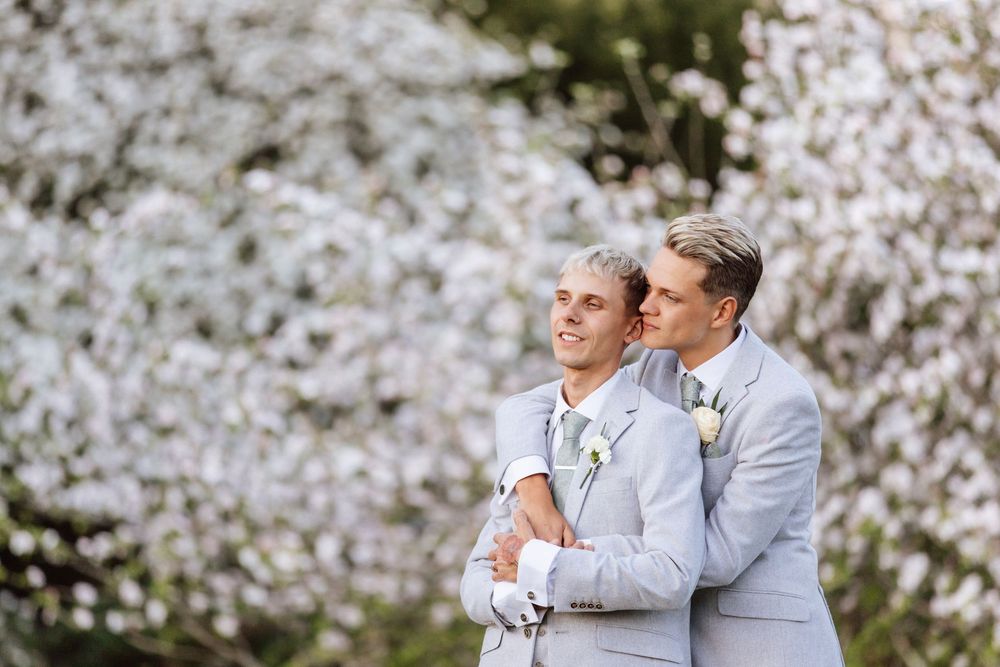 Gay couple with white blossoms The Ravenswood
