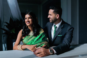 A Houston couple in formal attire shares a romantic moment on engagement day with the woman wearing an elegant green saree.
