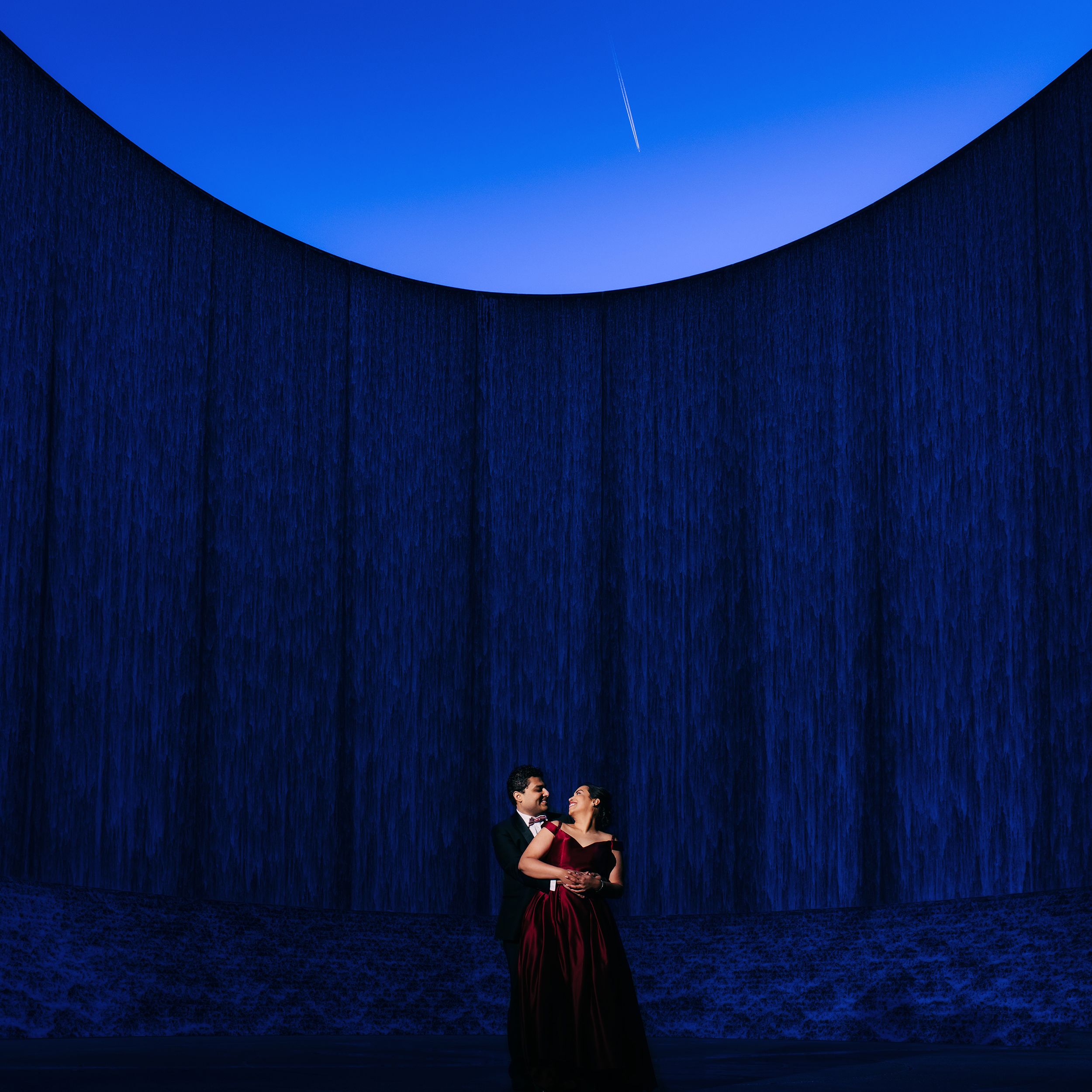 Couple shoot in suit and gown in front of the Waterwall in Houston, TX.