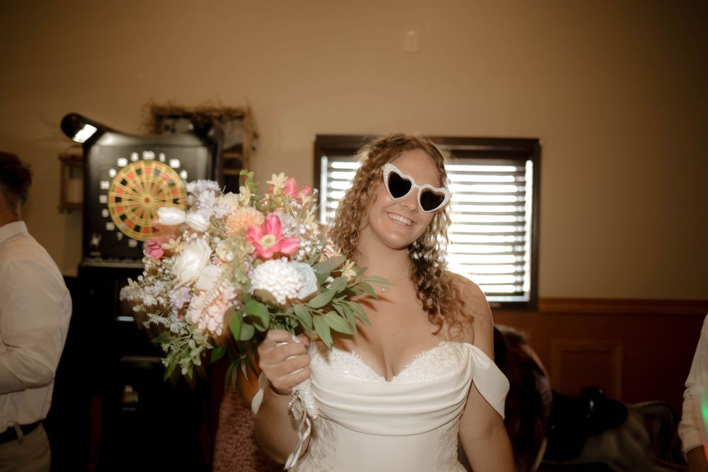 Wedding celebration in a rustic venue with floral decorations and warm lighting.