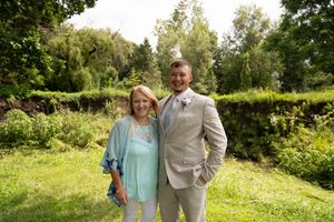 Outdoor wedding photos taken in a lush green garden setting on a sunny day.
