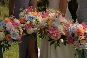 Close-up of wedding bouquets featuring pink, purple, and white flowers with green foliage.