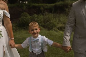 Wedding party members share candid laughter in a garden setting.