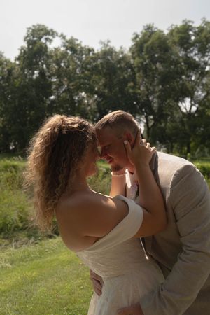 A couple embraces in an intimate moment during their outdoor wedding photoshoot.