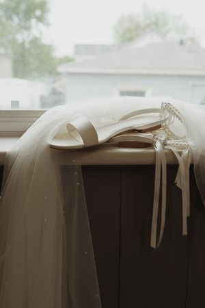 Wedding veil draped elegantly against a window creating a soft silhouette.