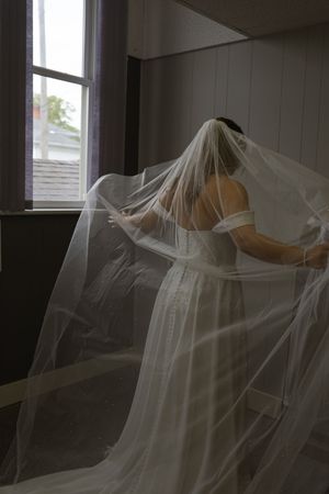 Ethereal bridal portrait with flowing veil creating dramatic shadows.