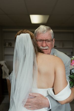 Emotional embrace captured during intimate wedding moment indoors.