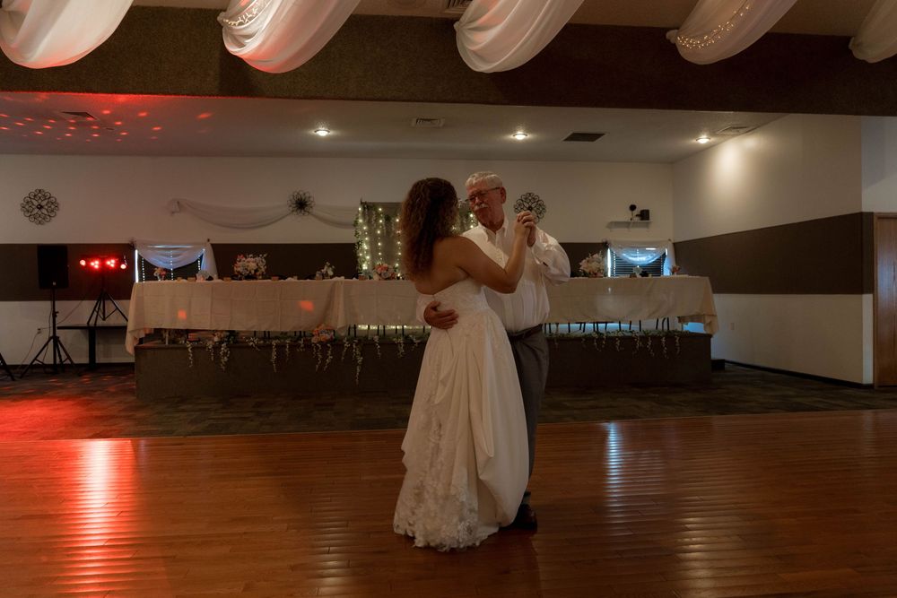 Wedding reception venue with wooden dance floor and ambient lighting.