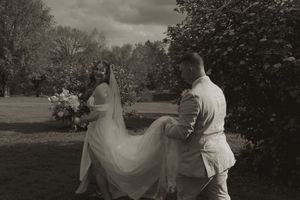 A couple shares a playful moment outdoors as the bride's dress flows in the breeze.