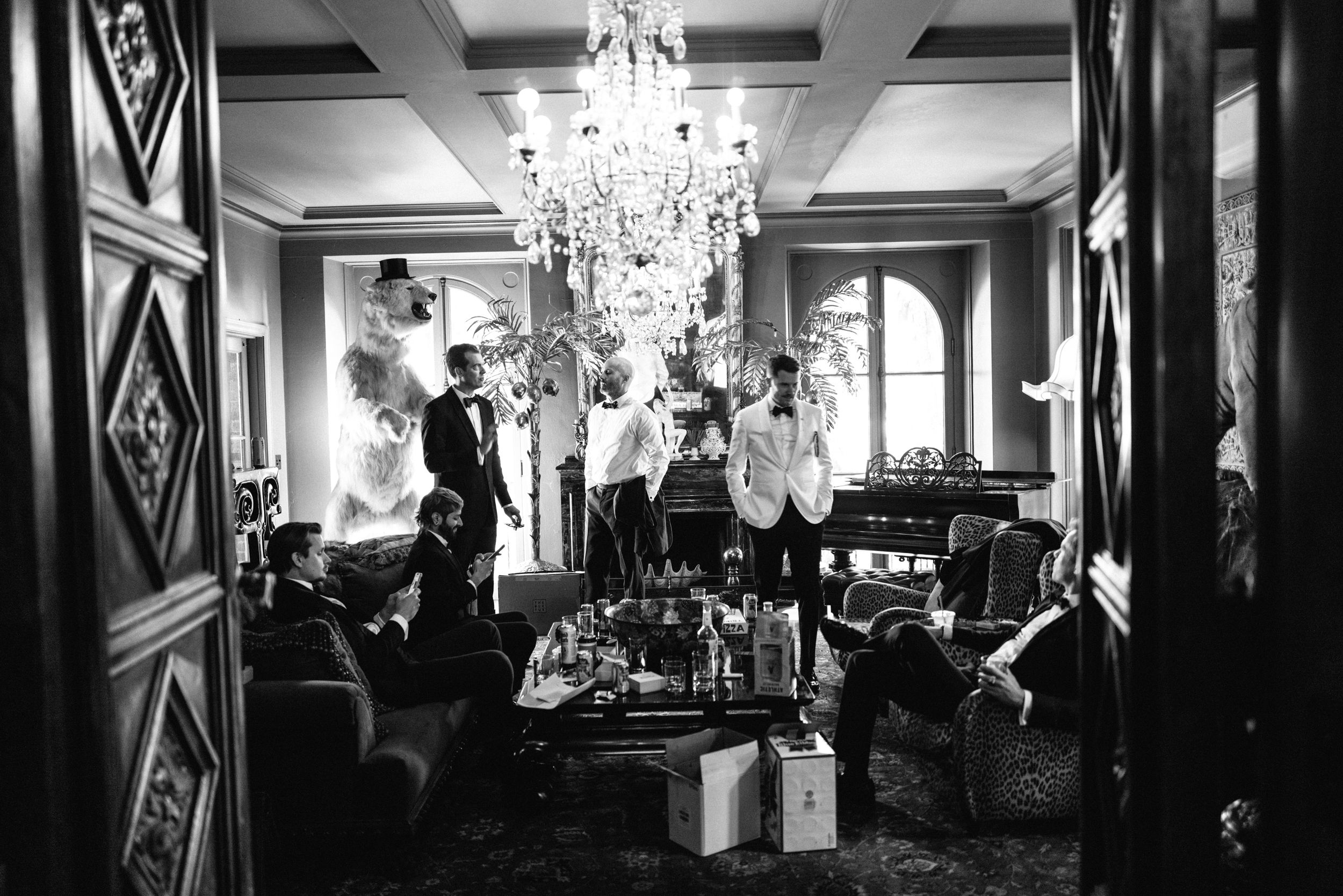 Elegant reception space with ornate chandelier and guests mingling in formal attire.