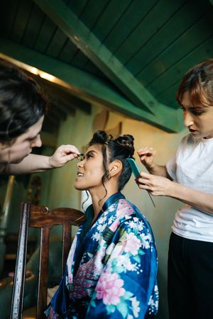 Wedding day preparation scene with traditional floral robe and styling session.