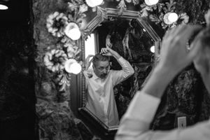 Black and white photo showing ornate mirror with glowing lights.