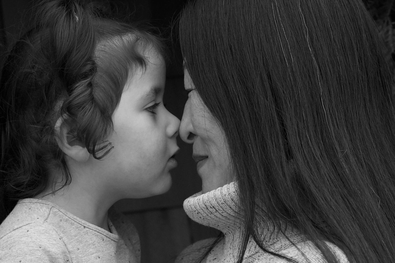 Family portrait of a woman nuzzling her young daughter's nose in Freeport Maine. Black and white photograph.
