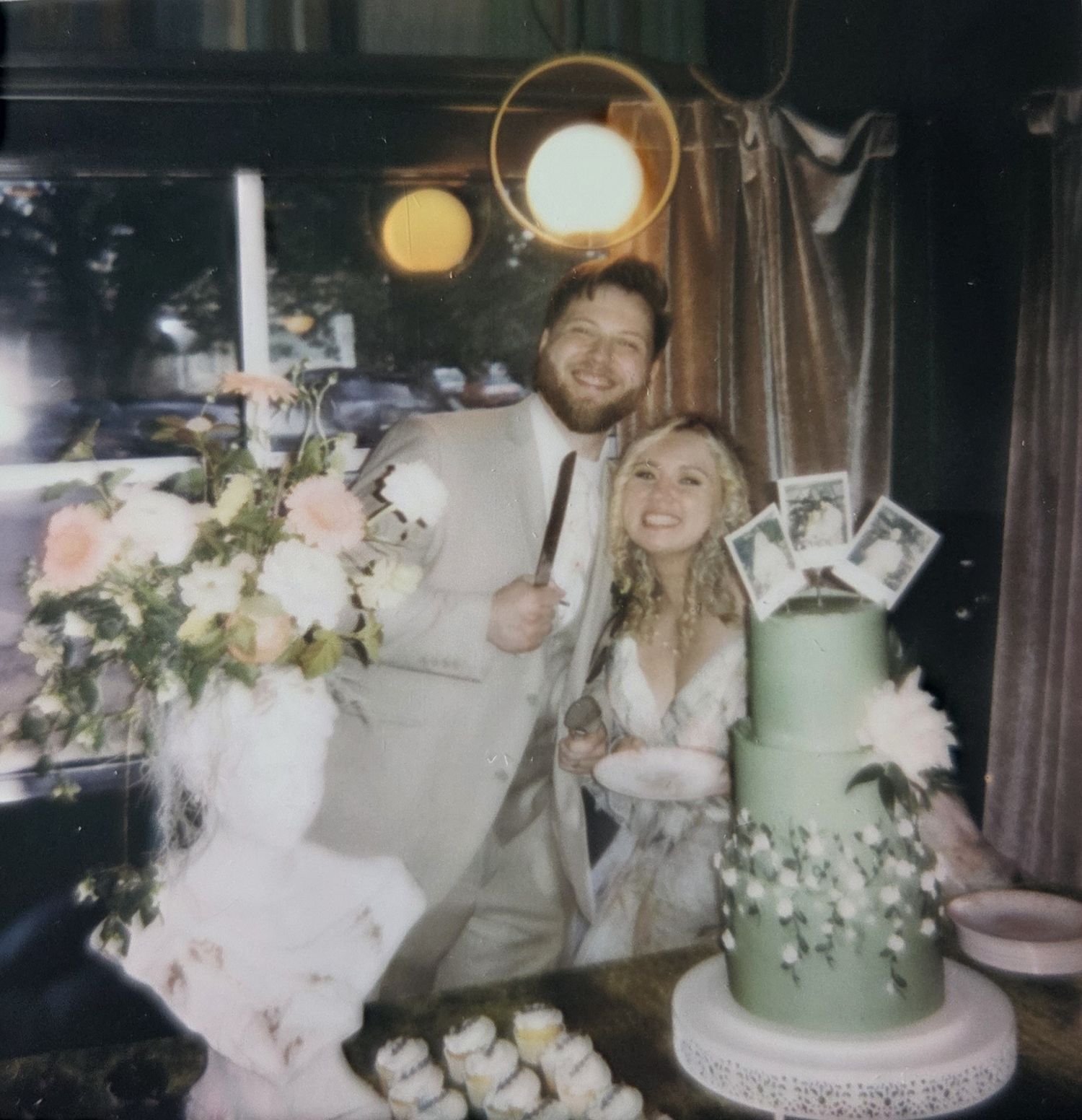 Retro-style photo of a couple posing indoors with white curtains in background.