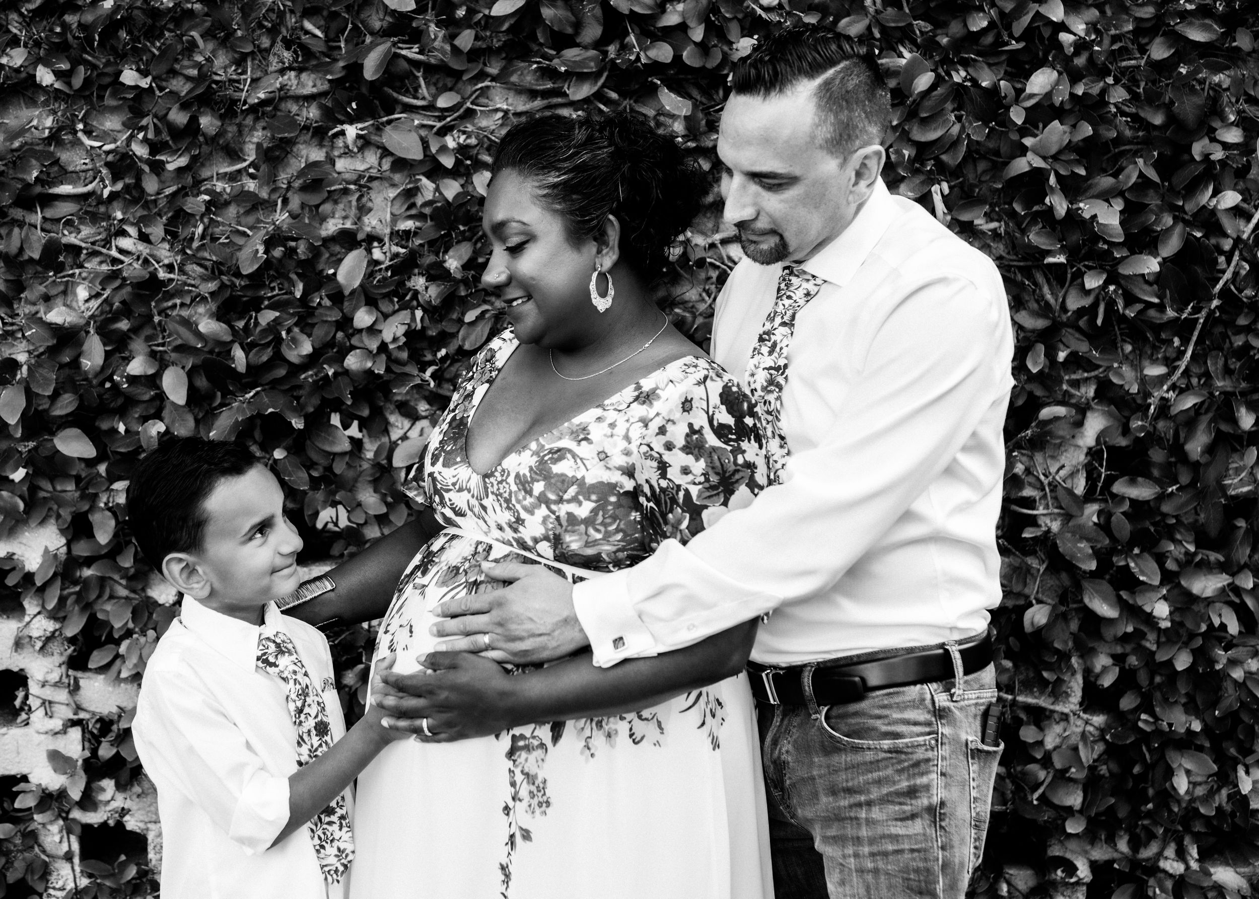 Black and white Maternity session in Amherstburg with pregnant woman, husband, and her beloved son at sunset.