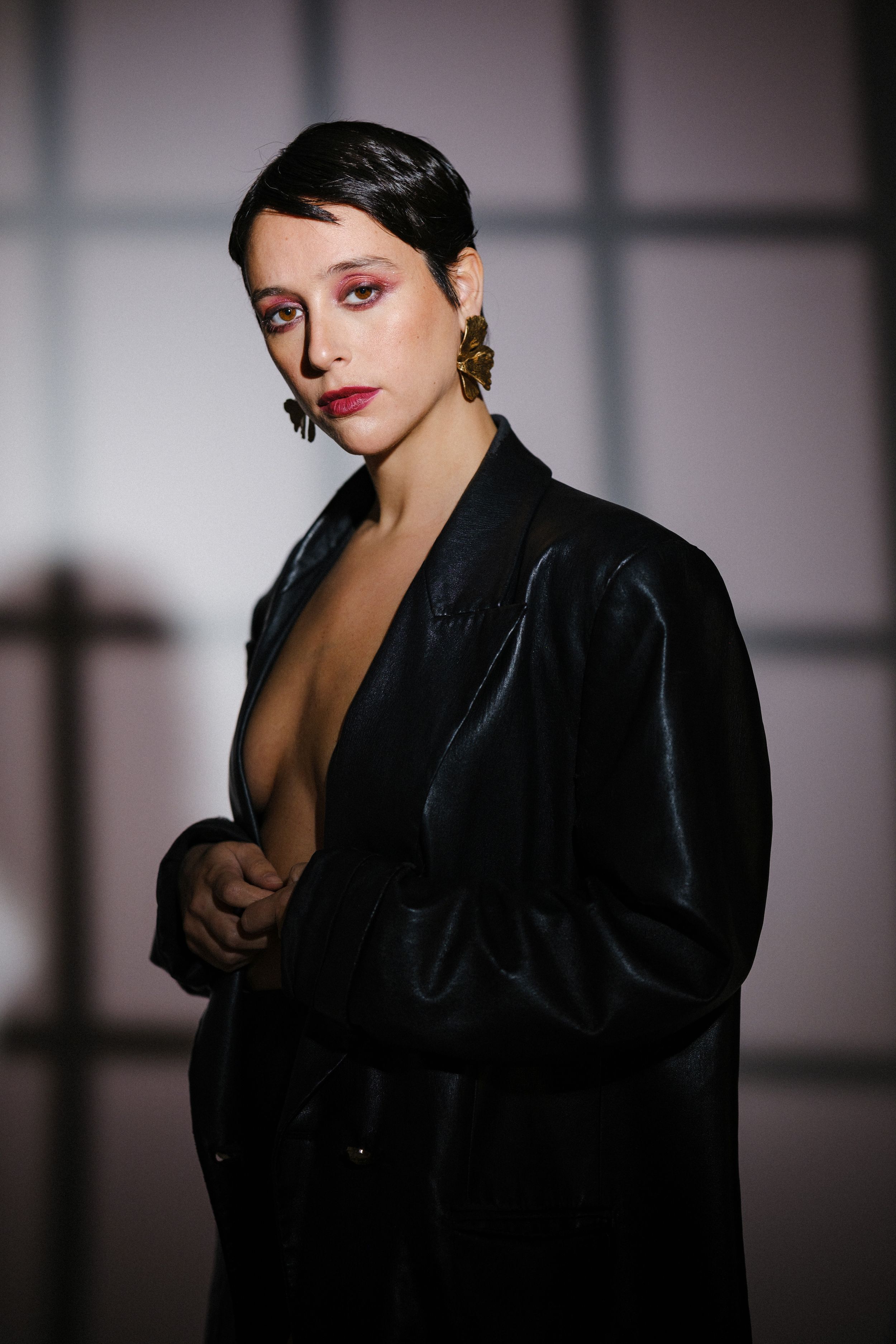 Moody fashion photograph with deep shadows and bold red lipstick.