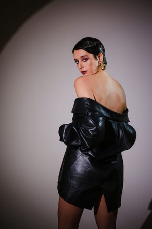 Stylish black leather jacket shown in artistic studio lighting.