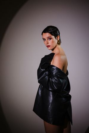 Elegant studio portrait highlighting dramatic black leather fashion.