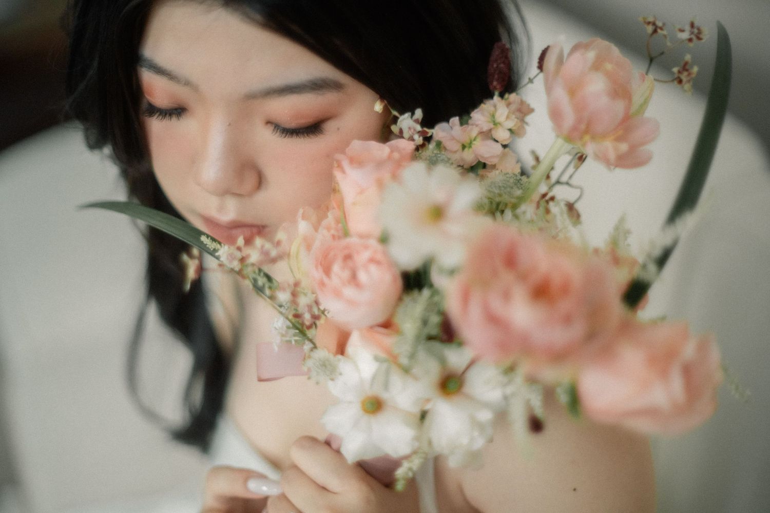 Close-up shot of delicate pink roses and white flowers in soft focus.