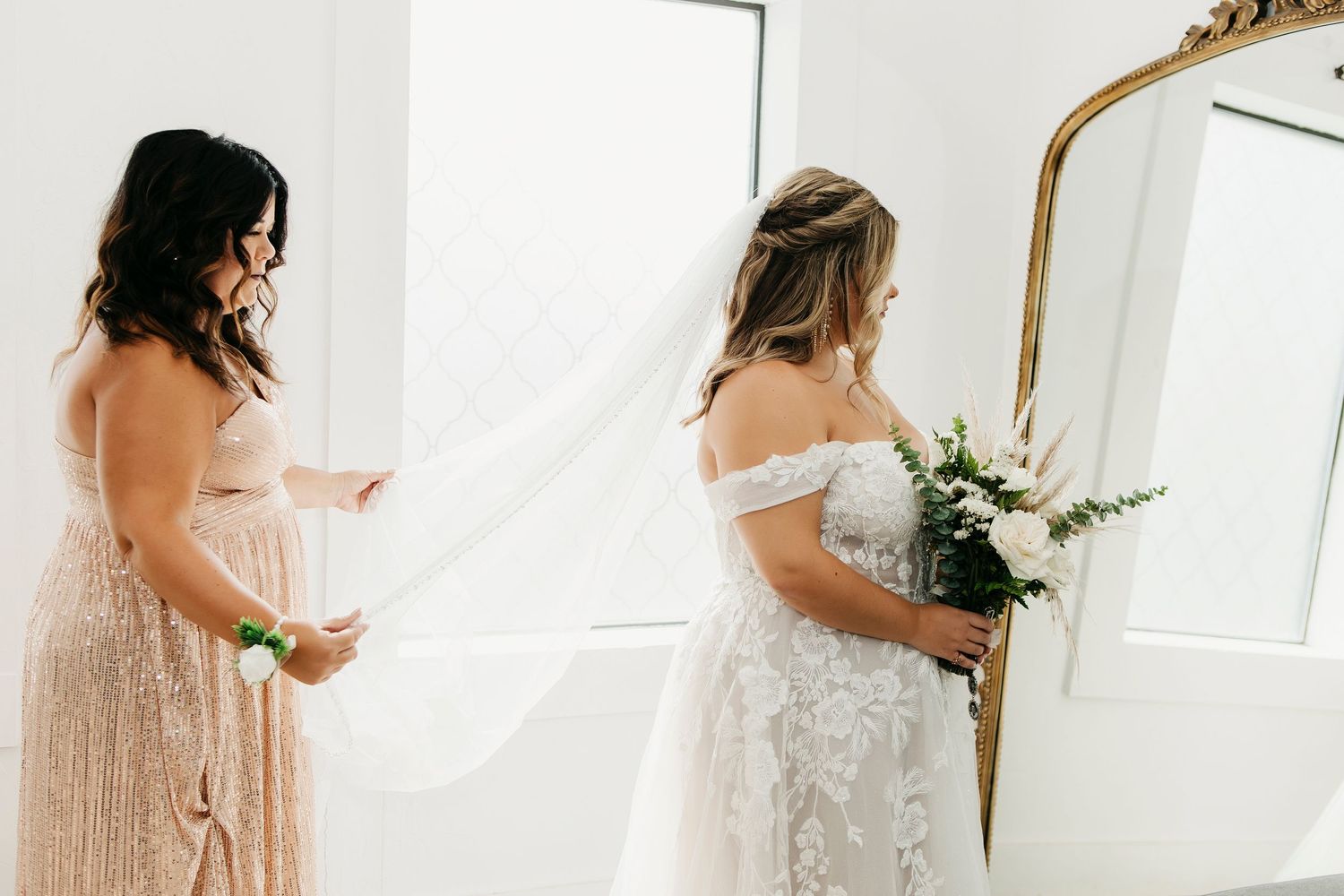 Elegant white wedding dress photographed in a bright indoor setting.