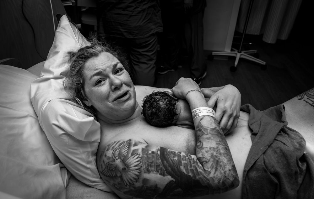 Medical professionals attend to patient in black and white hospital scene.